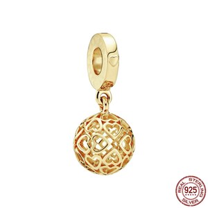 Puede incluir: Encanto dorado con una esfera colgante hecha de un delicado dise&ntilde;o de celos&iacute;a en forma de coraz&oacute;n. El encanto tiene un peque&ntilde;o coraz&oacute;n en el lazo superior.