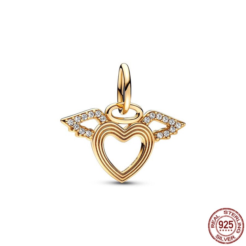 Puede incluir: Un charm dorado con un dise&ntilde;o en forma de coraz&oacute;n y alas de &aacute;ngel. Las alas est&aacute;n adornadas con piedras de circonita c&uacute;bica transparentes. El charm es adecuado para usar con una pulsera de charms.