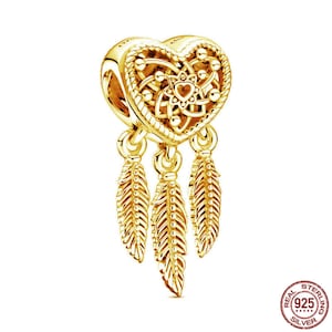 Puede incluir: Encanto dorado en forma de coraz&oacute;n con tres plumas colgantes. El encanto est&aacute; hecho de plata de ley y es una opci&oacute;n popular para la elaboraci&oacute;n de joyas.