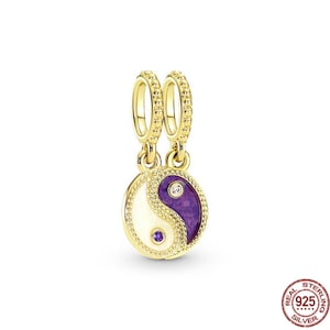Puede incluir: Encanto dorado con un s&iacute;mbolo yin yang morado y blanco con dos peque&ntilde;as piedras transparentes. El encanto tiene dos lazos dorados para sujetarlo a una pulsera.