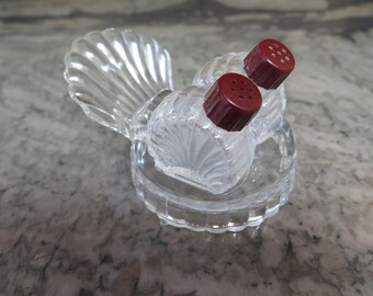 Pequeño par de saleros y pimenteros vintage de vidrio transparente con soporte a juego