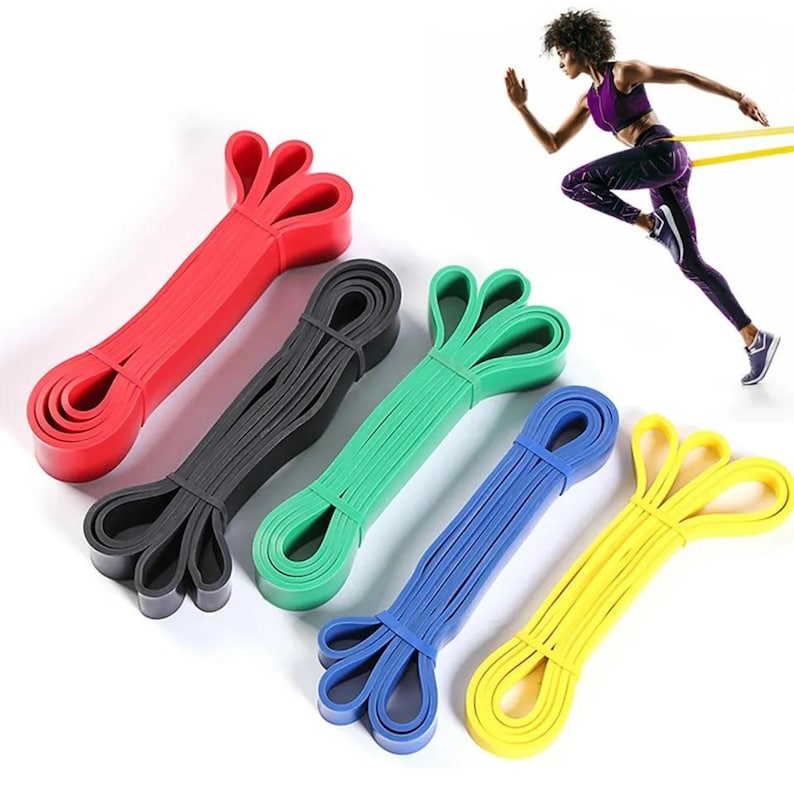 May include: Set of five resistance bands in different colors: red, black, green, blue, and yellow. The bands are stacked on top of each other, with the red band on top and the yellow band on the bottom.