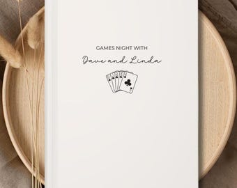 May include: White notebook with the text "Games Night with Dave and Linda" and a black and white illustration of playing cards.