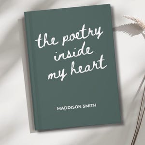 May include: A hardcover book with a teal cover featuring the white text "the poetry inside my heart" in a handwritten font. The author's name, Maddison Smith, is printed below the title. The book is displayed on a light surface.