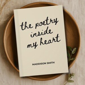 May include: A cream-colored book titled "the poetry inside my heart" in a handwritten font, with the author's name, Maddison Smith, at the bottom. The book rests in a wooden bowl with greenery.
