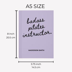 May include: A5 size lavender notebook with the text "badass pilates instructor." in black script. The notebook measures 8 inches tall and 5.75 inches wide. The name "MADDISON SMITH" is printed below the text.