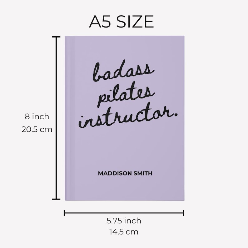 May include: A5 size lavender notebook with the text "badass pilates instructor." in black script. The notebook measures 8 inches tall and 5.75 inches wide. The name "MADDISON SMITH" is printed below the text.