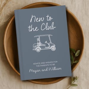 Op de afbeelding: Een grijs gastenboek met de tekst "New to the Club" en een illustratie van een golfkar. Het boek bevat de tekst "Advice and Wishes for the Parents to Be" en de namen "Megan and William".