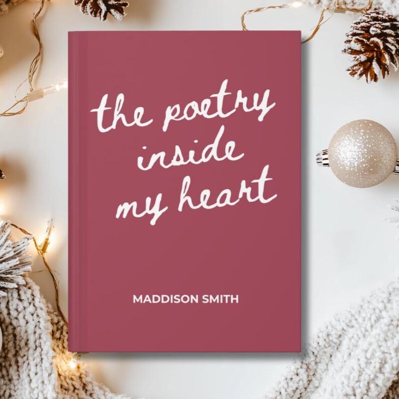 May include: A hardcover book with a burgundy cover featuring the text "the poetry inside my heart" in white script. The author's name, Maddison Smith, is printed below. The book is surrounded by festive decorations.