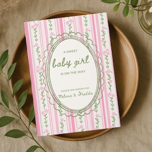 May include: A baby shower card with pink and white striped background and floral accents. The card reads "A Sweet Baby Girl Is On The Way" and includes space for advice and wishes for Melanie & Freddie.