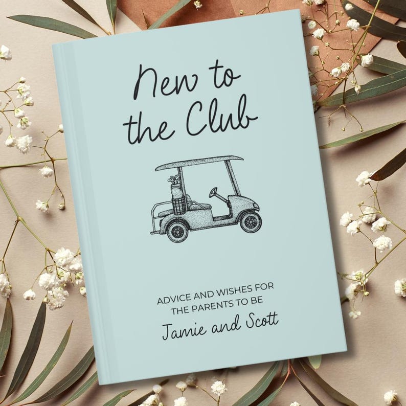 Op de afbeelding: Een lichtblauw boek met de tekst "New to the Club" in zwart schrift. Daaronder staat een zwart-wit illustratie van een golfkarretje. De tekst "ADVICE AND WISHES FOR THE PARENTS TO BE Jamie and Scott" staat ook op de kaft.