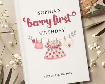 Puede incluir: Una portada de libro blanca con el texto "SOPHIA'S berry first BIRTHDAY" en escritura rosa. Debajo, una cuerda de ropa muestra ropa de bebé: una braga, un vestido con detalles de fresas y un babero. La fecha "SEPTEMBER 30, 2025" está en la parte inferior.