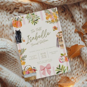 Puede incluir: Una invitación con temática otoñal con el texto "The Fall Isabelle Turned Sixteen". El diseño incluye ilustraciones en acuarela de calabazas, un gato negro, manzanas, una bufanda y una cesta de frutas, con rayas rosas y blancas.