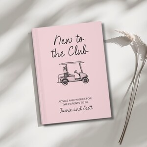 Op de afbeelding: Een roze hardcover boek met de tekst "New to the Club" in zwart schrift. Onder de tekst staat een zwart-wit illustratie van een golfkar. De tekst "ADVICE AND WISHES FOR THE PARENTS TO BE" staat eronder, gevolgd door de namen "Jamie and Scott".