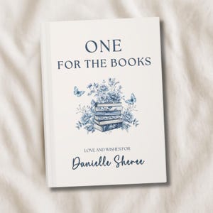 Puede incluir: Un libro de tapa dura con el texto "ONE FOR THE BOOKS" en azul marino. La portada presenta un diseño floral con flores azules, mariposas y una pila de libros. También se incluye el texto "LOVE AND WISHES FOR Danielle Sherve".