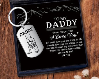 May include: A silver keychain with a dog tag that reads "Daddy" with two small hands holding each other. The dog tag is in a black box with a message that reads "To My Daddy Never forget that I Love You".