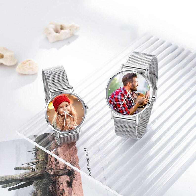 Peut inclure: Deux montres &agrave; bracelet en maille argent&eacute;e avec des cadrans ronds. Les cadrans des montres pr&eacute;sentent des photos personnalis&eacute;es d'une jeune fille et d'un homme avec un chien.