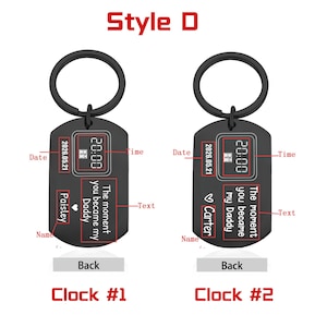 May include: Black metal keychains with a circular ring and a rectangular tag. The tags display a date, time, and the text "The moment you became my Daddy." One keychain has the name "Paisley," the other "Carter."