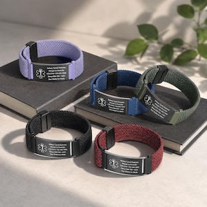 May include: Five medical alert bracelets with woven elastic bands in lavender, blue, olive green, black, and maroon. Each features a rectangular metal plate with a Star of Life emblem and engraved text including Kelsey, Type 2 Diabetes, and emergency contacts.