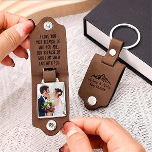 May include: Two brown leather keychains. One keychain has a photo of a couple and the text "I LOVE YOU NOT BECAUSE OF WHO YOU ARE, BUT BECAUSE OF WHO I AM WHEN I AM WITH YOU". The other keychain has the names "Aubrey & Nicky" and the date "May 12, 2025".