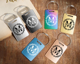 May include: Six personalized luggage tags with a wreath design and the name "MICHAEL" engraved on each. The tags are in different colors: silver, black, rainbow, blue, and rose gold.