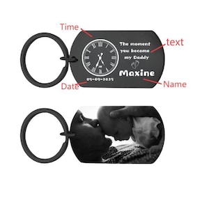 May include: Black metal keychain with a clock design and the text "The moment you became my Daddy" and the name "Maxine". The second keychain shows a black and white photo of a parent and baby.