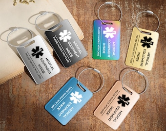 May include: Six different coloured luggage tags with a silver metal ring and cable. Each tag has a white medical symbol and the text "MEDICAL EQUIPMENT INSIDE" with the instruction "PLEASE HANDLE WITH CARE".