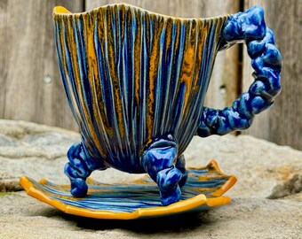 handmade whimsical porcelain teacup and saucer in blue and orange