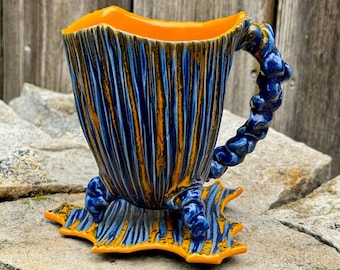 handmade whimsical porcelain teacup and saucer in blue and orange