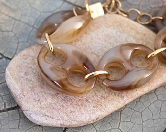 Gebruikte Milë Mila-armband: goudkleurig roestvrij staal en gemarmerde acrylschakelkralen