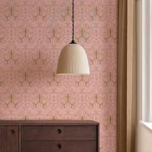 May include: A pale pink wallpaper featuring a gold butterfly design. A cream-coloured, ribbed pendant light hangs from the ceiling. A dark brown wooden dresser is visible at the bottom of the image.