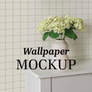 Peut inclure: Vase en céramique blanche avec un corps rond et un col étroit, remplie d'un bouquet d'hortensias blancs. Le vase est posé sur un comptoir blanc avec le texte "Wallpaper MOCKUP" en lettres noires.