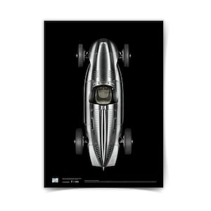 May include: A top-down view of a vintage silver race car against a black background. The car has a streamlined design with four small wheels and a cockpit. The image is a print, with the text "1/500" at the bottom.