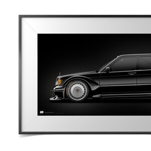Op de afbeelding: Een ingelijste print met een zwarte oldtimer tegen een donkere achtergrond. De zijkant van de auto is zichtbaar, met de nadruk op de wielen en koplampen. De afbeelding is een gedetailleerde weergave van het ontwerp van het voertuig.