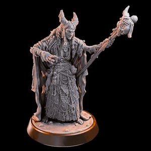 May include: A detailed miniature figurine of a horned, cloaked figure holding a staff with a bird-like creature on top. The figure is adorned with intricate details and appears to be a wizard or sorcerer.