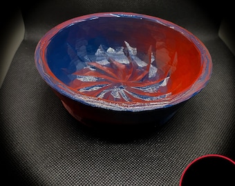 May include: A blue and red swirl design bowl with a textured surface. The bowl is made of a smooth, hard material.