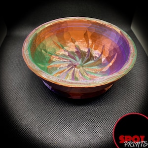 Peut inclure: Un bol coloré et iridescent avec un motif tourbillonnant et texturé. Le bol est fait d'un matériau lisse et dur et a une finition brillante.