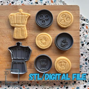 Puede incluir: Un conjunto de seis cortadores de galletas en varias formas, incluyendo una cafetera, granos de café y una taza de café. Los cortadores están hechos de plástico gris y están dispuestos sobre una superficie de madera. El texto "STL/DIGITAL FILE" está impreso en la superficie.