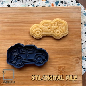 May include: A pumpkin-themed cookie cutter and a baked cookie in the shape of a vintage truck carrying pumpkins. The dark blue plastic cutter is next to the baked cookie on a wooden surface. The text "STL/DIGITAL FILE" is in the image.