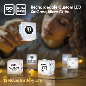 May include: Illuminated white micro cubes with custom logos and QR codes. One cube shows a Pinterest logo, another says "Your Custom Logo", and a third displays an Instagram logo. The text "12 Hours Battery Life" is visible. These are rechargeable LED lights.