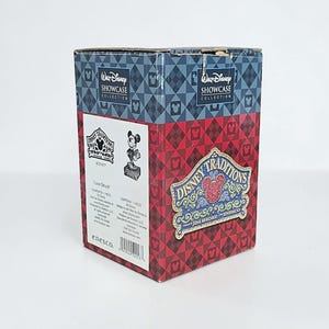 May include: A Disney Traditions box with a red and blue diamond pattern. The box features the Walt Disney Showcase Collection logo and a Mickey Mouse figurine. The box also has the text "Love Struck" and the Disney Traditions logo.