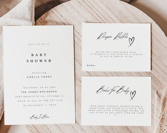 May include: A white baby shower invitation with black text. The invitation includes the name Amelia Jones, the date and time of the shower, and the location. There are two additional cards for a nappy raffle and a request for books for the baby.