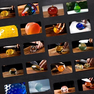 May include: A collection of glass fruit sculptures, including an apple, pear, and pineapple, are displayed. Each piece is shown being cut with a knife, showcasing the internal design and texture of the glass art.