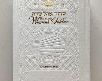 May include: White book cover with gold embossed lettering and a crown. The title reads "Siddur Ohel Sarah Women's Siddur Klein Edition ArtScroll Series".