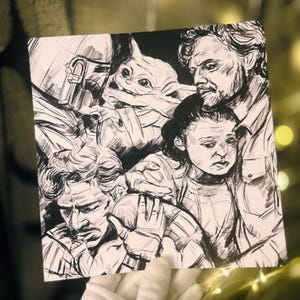 Puede incluir: Ilustración en blanco y negro con personajes de una popular serie de ciencia ficción. La obra de arte representa a un Mandaloriano, un niño y otras dos figuras en un estilo detallado, similar a un boceto. La imagen es sostenida por una mano enguantada.