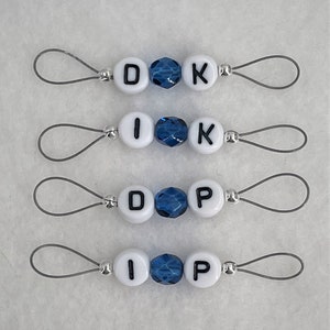 May include: Four sets of white letter beads with blue crystal beads on a silver wire loop. The letters spell out "DOK", "IK", "DOP", and "IP".