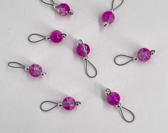 May include: A set of ten pink and silver bead and loop stitch markers. The markers are made of glass beads with a silver loop attached.