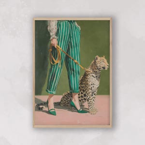 May include: A framed art print featuring a person in green and white striped pants and green heels, holding a yellow leash attached to a leopard. The background is a solid green, and the floor is pink.