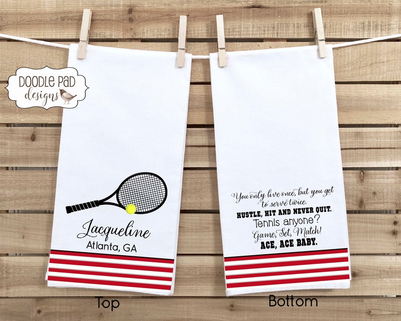 K&ouml;nnte beinhalten: Zwei wei&szlig;e K&uuml;chent&uuml;cher mit roten Streifen. Das obere Handtuch zeigt einen schwarz-wei&szlig;en Tennisschl&auml;ger mit einem gelben Tennisball und den Text "Jacqueline Atlanta, GA". Das untere Handtuch hat den Text "You only live once, but you get to serve twice. Hustle, hit and never quit. Tennis anyone? Game, Set, Match! Ace, Ace Baby."