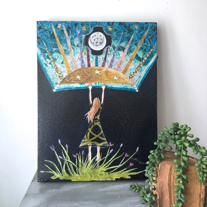 May include: A mixed media painting of a woman reaching up to a large, colorful, mosaic-like moon. The moon is surrounded by stars and rays of light. The woman is wearing a black dress and has long, red hair. The background is black with a textured pattern.